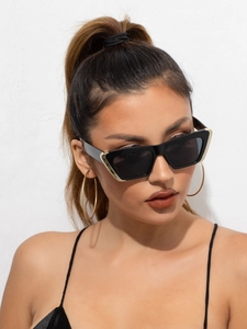 Detail view of modern cat eye sunglasses with golden triangle metal accents on the frame