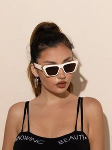 Close-up of white rectangle sunglasses with gold hinges worn by a fashion model