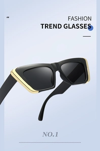 Detail of square cat eye sunglasses with black frame and golden metal rim accents