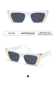 Detail view of white cat eye sunglasses with gold triangle accents and dark grey lenses