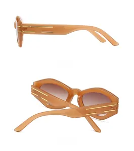 Dettaglio occhiali da sole cat-eye ambra con strisce dorate sulle aste larghe