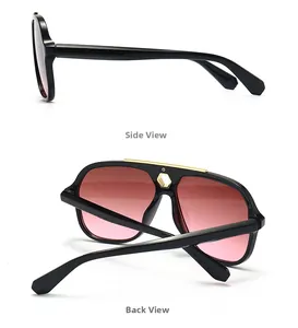 Detail of black sunglasses featuring a gold metal top bar and pink gradient lenses