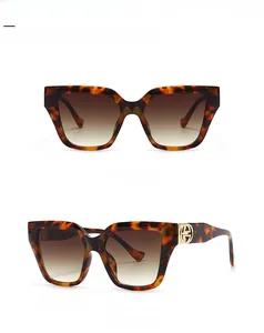 Detail view of leopard print sunglasses with gradient tan lenses and gold logo hinge