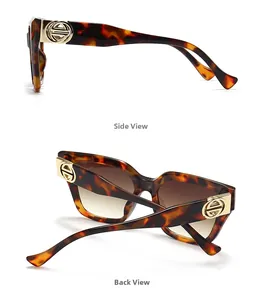 Detail view of tortoiseshell sunglasses frame with gold logo and dark gradient lenses