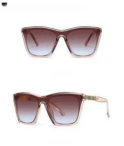 Détail de lunettes de soleil carrées avec verres dégradés bleu et marron et charnière métal
