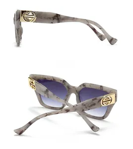 Detail of marble pattern sunglasses with blue gradient lenses and gold metal accents