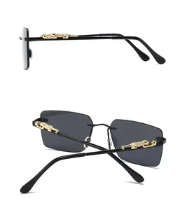 Detail view of gold leopard-shaped metal hinge with rhinestones on narrow black sunglasses