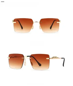 Detail view of gold leopard head hinge on rimless sunglasses with tan gradient lenses