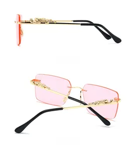 Detail of gold leopard hardware on pink gradient lens rimless rectangle sunglasses