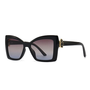 Lunettes de soleil papillon noires chic avec verres dégradés violets et détails dorés