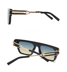 Detail view of square black sunglasses with gold cutout temples and gradient lenses
