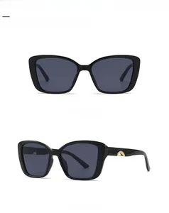 Macro detail of black cat-eye sunglasses with golden arc temple decor on white background