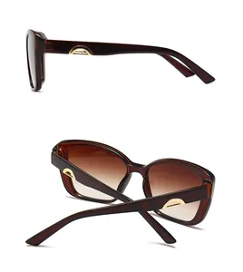 Detail view of tortoiseshell sunglasses with gold metal buckle and gradient brown lenses