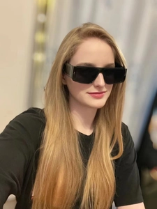 Detailopname van zwarte rechthoekige oversized zonnebril met brede pootjes op model