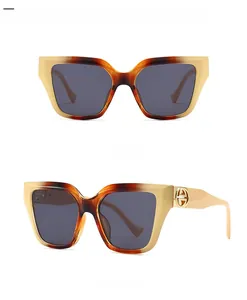 Square tortoise shell sunglasses with dark lenses and gold circular detail on temple