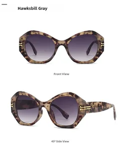 Detailansicht der geometrischen Schildpatt-Sonnenbrille mit Goldakzenten und grauen Gläsern