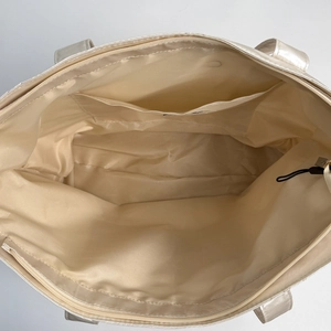 Top view of spacious tote interior with zipper pocket and satin lining detail