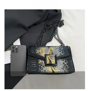 Détail macro du motif serpent et de la boucle carrée mate sur ce sac à bandoulière