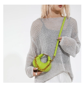 Macro view of bright lime green textured leather mini crescent bag with chunky gold chain