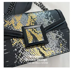 Détail du sac en cuir serpent avec boucle magnétique noire et chaîne en métal noirci
