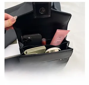 Détail du sac bandoulière serpent montrant l'intérieur spacieux avec deux compartiments