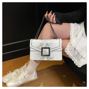 Détail du sac bandoulière blanc à motif serpent avec boucle noire et chaîne