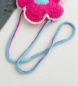 Détail d'un mini sac floral au crochet avec une longue bandoulière tissée à la main