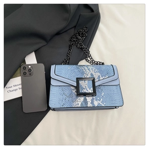 Détail du sac bandoulière serpent bleu avec boucle noire mate et bandoulière chaîne