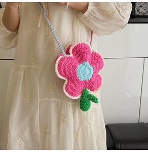Texture détaillée du sac à fleurs au crochet rose fait main avec centre bleu et feuilles