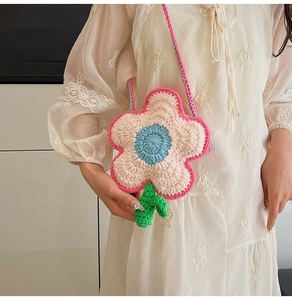 Handmade crochet flower shoulder bag featuring soft knit textures and green leaf charms