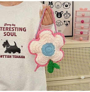 Détail du sac à fleurs au crochet fait main avec centre bleu et feuilles vertes