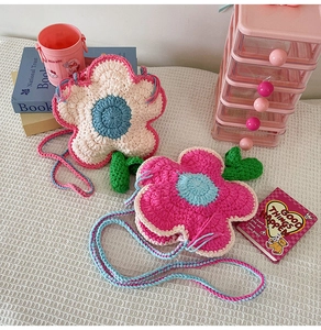 Détail du sac bandoulière en crochet fait main en forme de fleur avec feuilles vertes