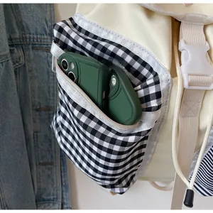 Detail of the checkered front pocket showing storage capacity for two smartphones