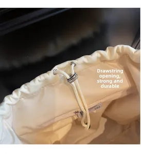 Close-up of drawstring opening with metal eyelets and interior zipper pocket