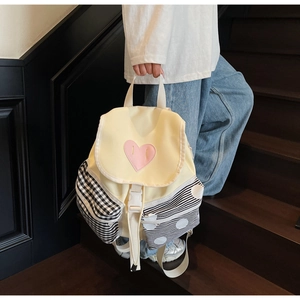 Detail of canvas backpack with pink heart and contrast patterned side pockets