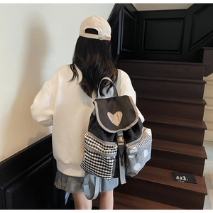 Detailed back view of a Japanese-style color-block canvas backpack with heart patch on model