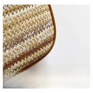 Gros plan sur la texture naturelle tressée à la main du sac seau avec bordure en cuir marron