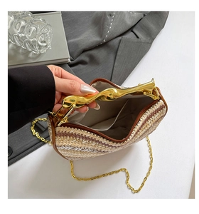 Détail de l'intérieur du sac tissé avec poignée dorée et bandoulière en chaîne