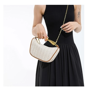 Détail du sac demi-lune tissé beige avec poignée fer à cheval dorée et garniture en cuir