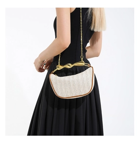 Détail du sac tressé crème avec poignée dorée sculpturale et bandoulière chaîne