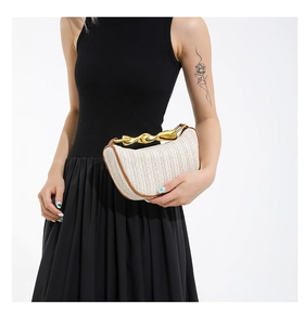 Détail du sac à main en paille tressée avec bordure brune et anse en métal doré
