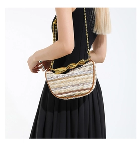 Détail du sac demi-lune tissé avec fermoir doré ondulé et bandoulière en chaîne