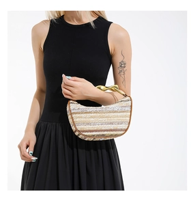 Détail d'un sac à main tissé à rayures avec une poignée métallique dorée de luxe