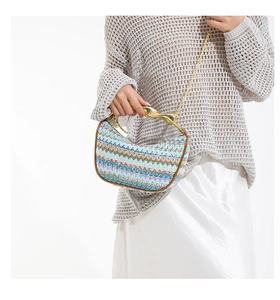 Détail du sac tressé avec poignée dorée en forme d'oiseau et motif zigzag coloré