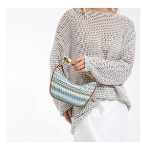 Détail d'un sac à main tissé multicolore avec poignée en métal doré de luxe