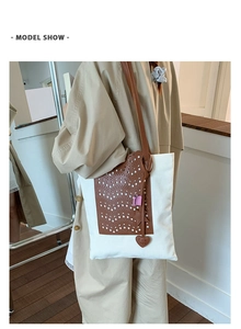 Detail of hollowed brown leather on canvas bucket bag with star and heart charms