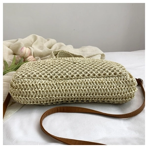 Detailsicht der beige Strohtasche mit braunem Riemen und dekorativen Tulpen