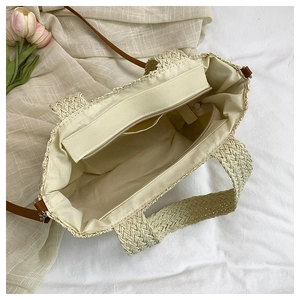 Draufsicht der Strohtasche mit Stofffutter, Reißverschlussfach und braunem Gurt