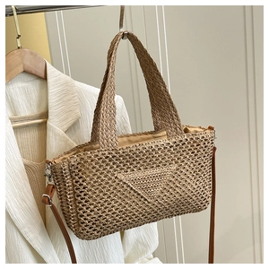 Detail der handgewebten Stroh-Tasche mit Dreiecksmuster und braunem Leder-Schultergurt