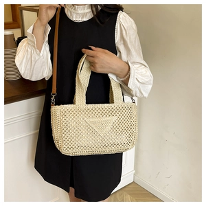 Detailansicht der gewebten Strohtasche mit Dreiecksmuster und Leder Schultergurt Design